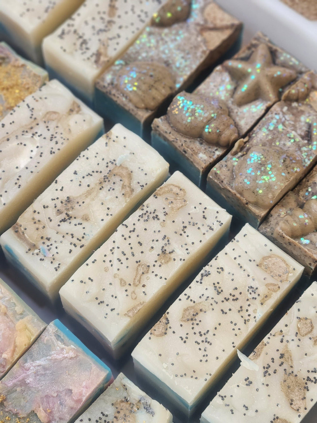 Handmade soap bars with natural ingredients arranged in rows for soap challenge ocean soap collection