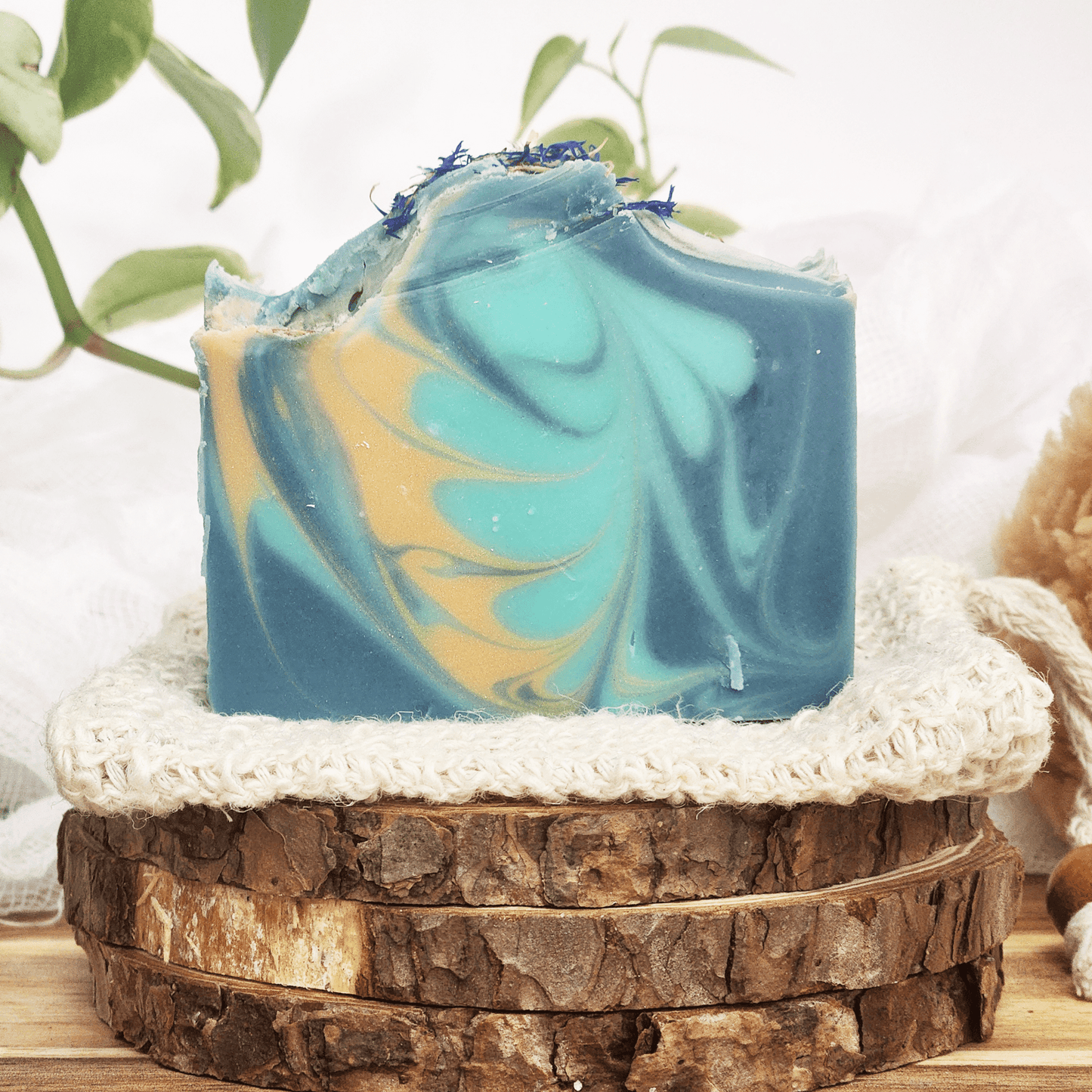 JOSSPURE blackberry sage mild shea butter soap bar with blue and yellow swirls on natural wooden display