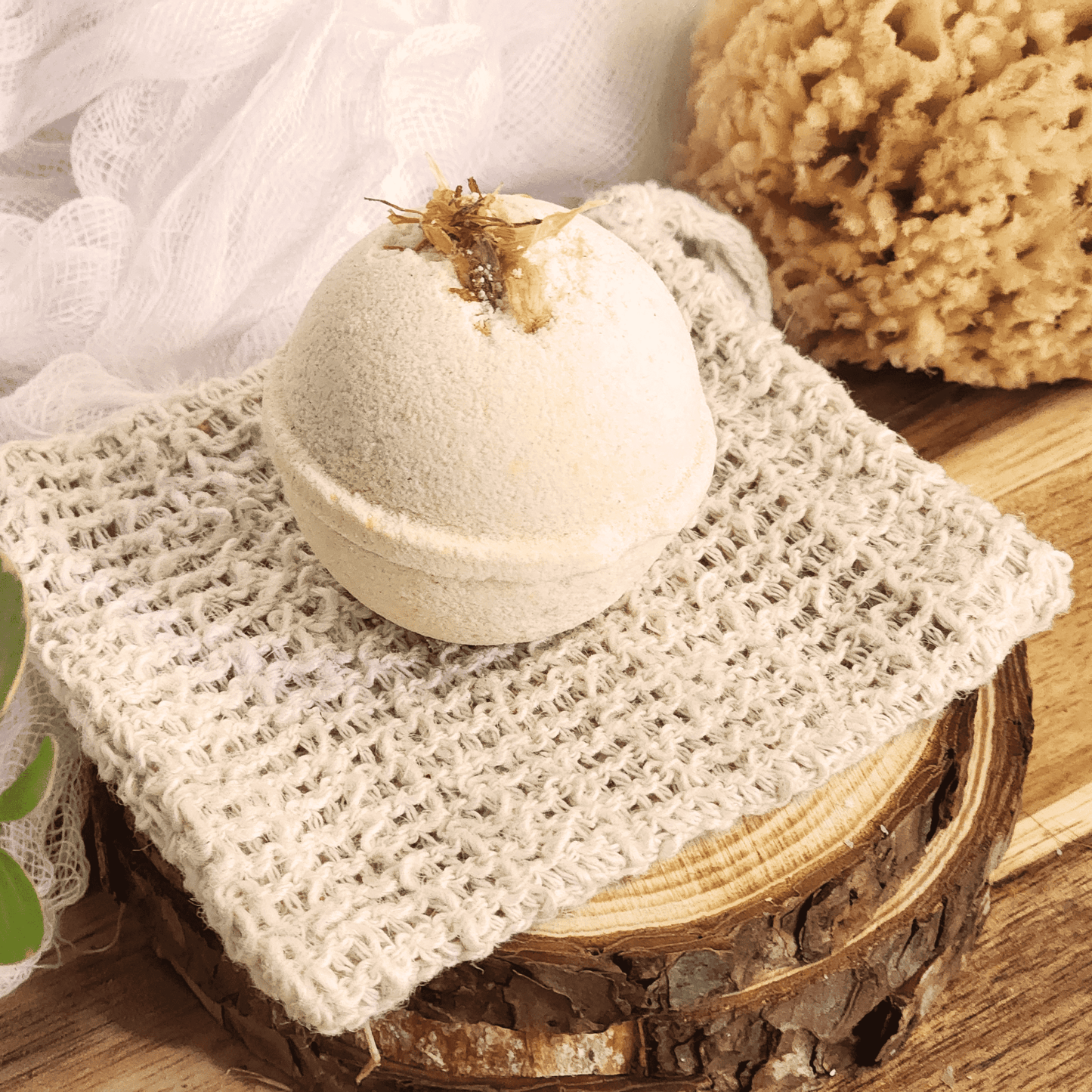Grapefruit mini bath bomb with dried flowers on natural cloth and wooden surface by JOSSPURE