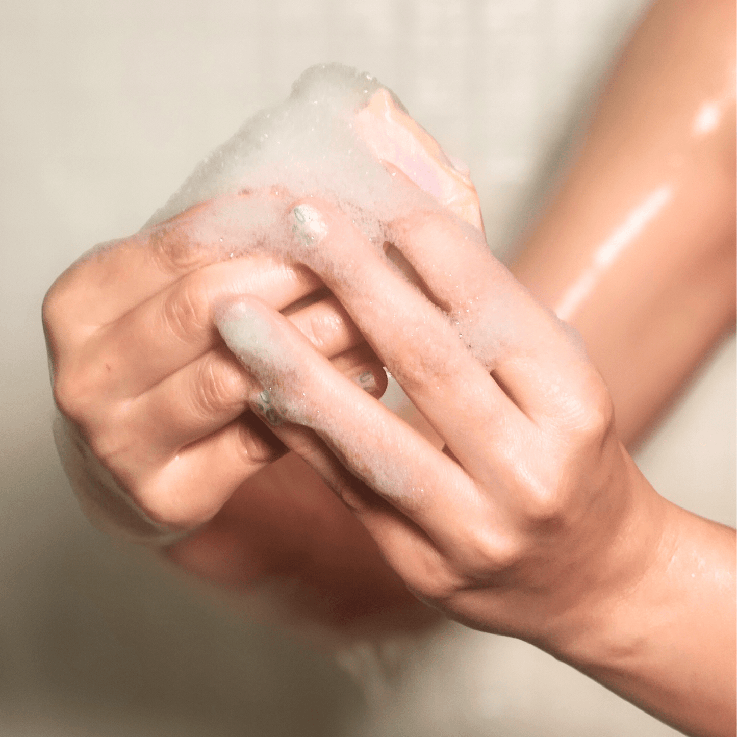 Hands holding and lathering lemongrass mild shea butter soap with foamy bubbles