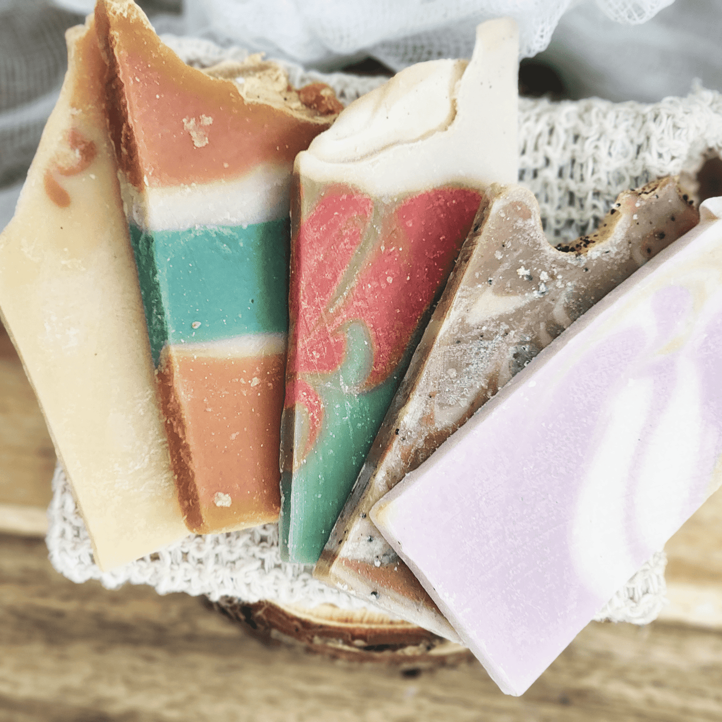 Artisan shea butter soap sampler with colorful handcrafted natural soap bars on textured fabric