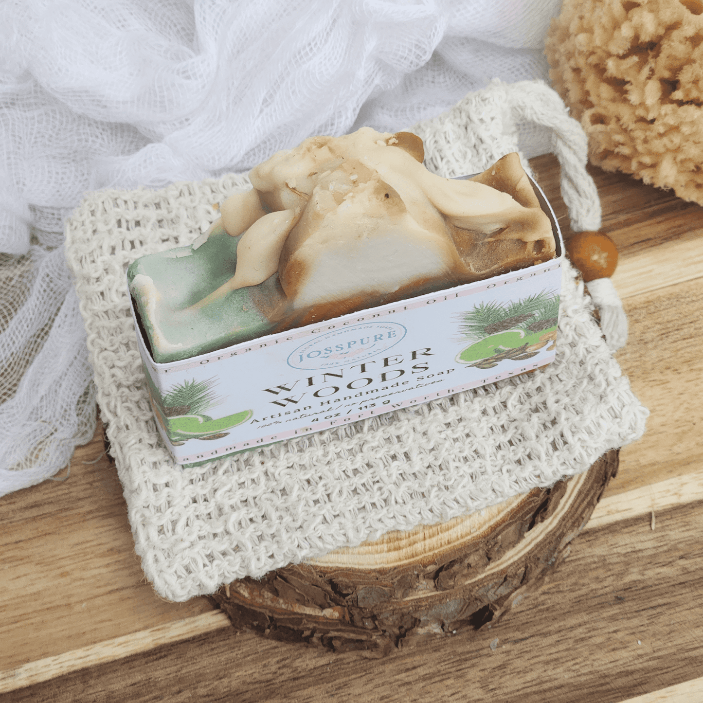 Christmas mild shea butter soap handmade by JOSSPURE displayed on a textured white cloth with natural bath accessories