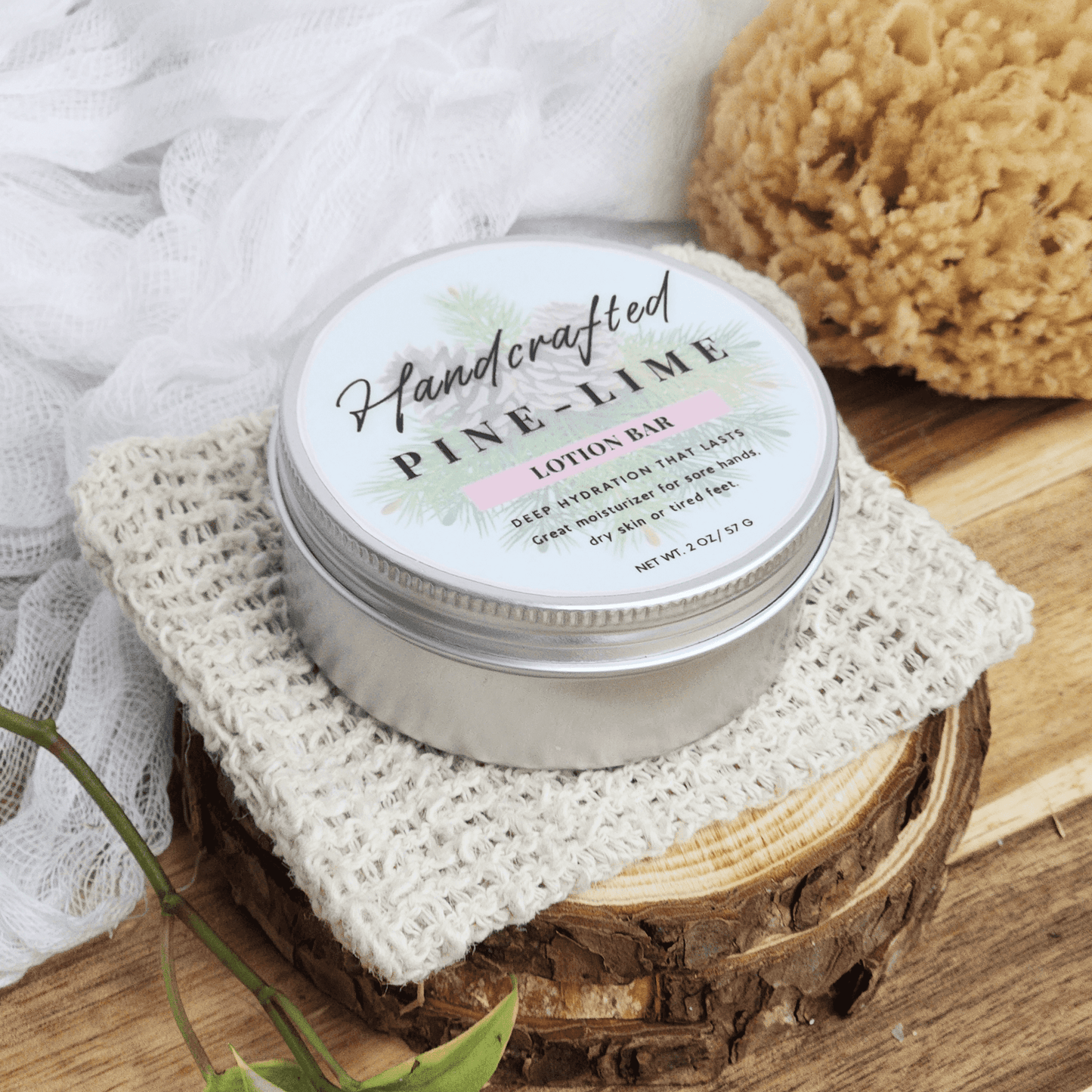 Handcrafted pine lime handmade lotion bars in a round silver tin on a textured cloth with natural decor