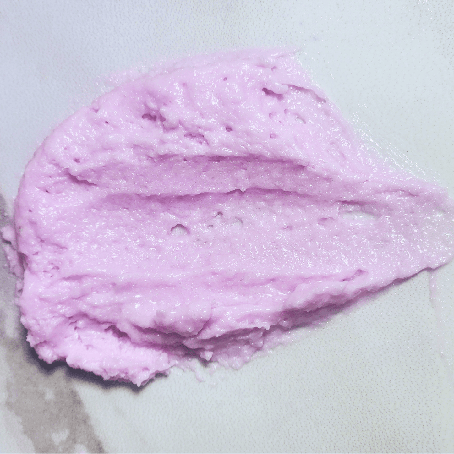 Close-up of JOSSPURE lavender luxury sugar scrub with creamy purple texture on white surface