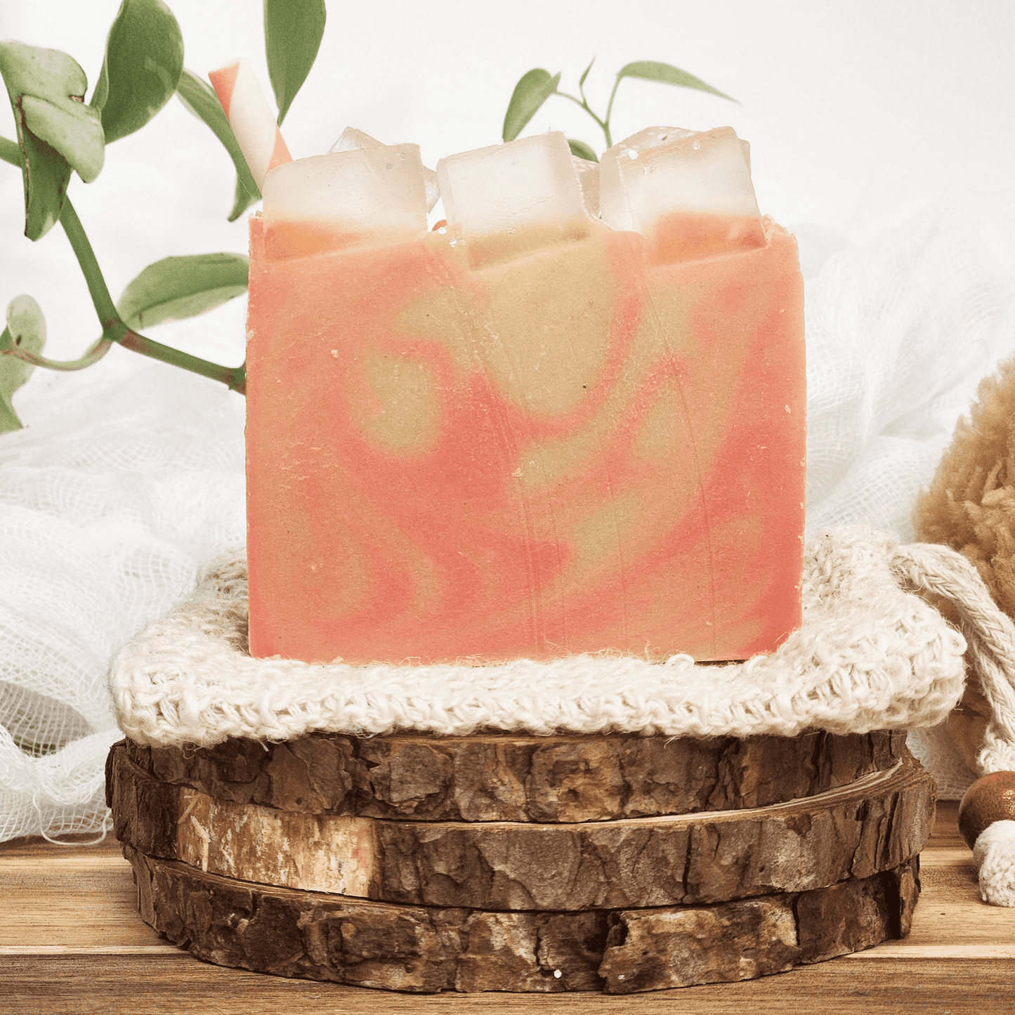 Handmade raspberry lemonade mild shea butter soap with pink and cream swirls displayed on wooden and fabric layers