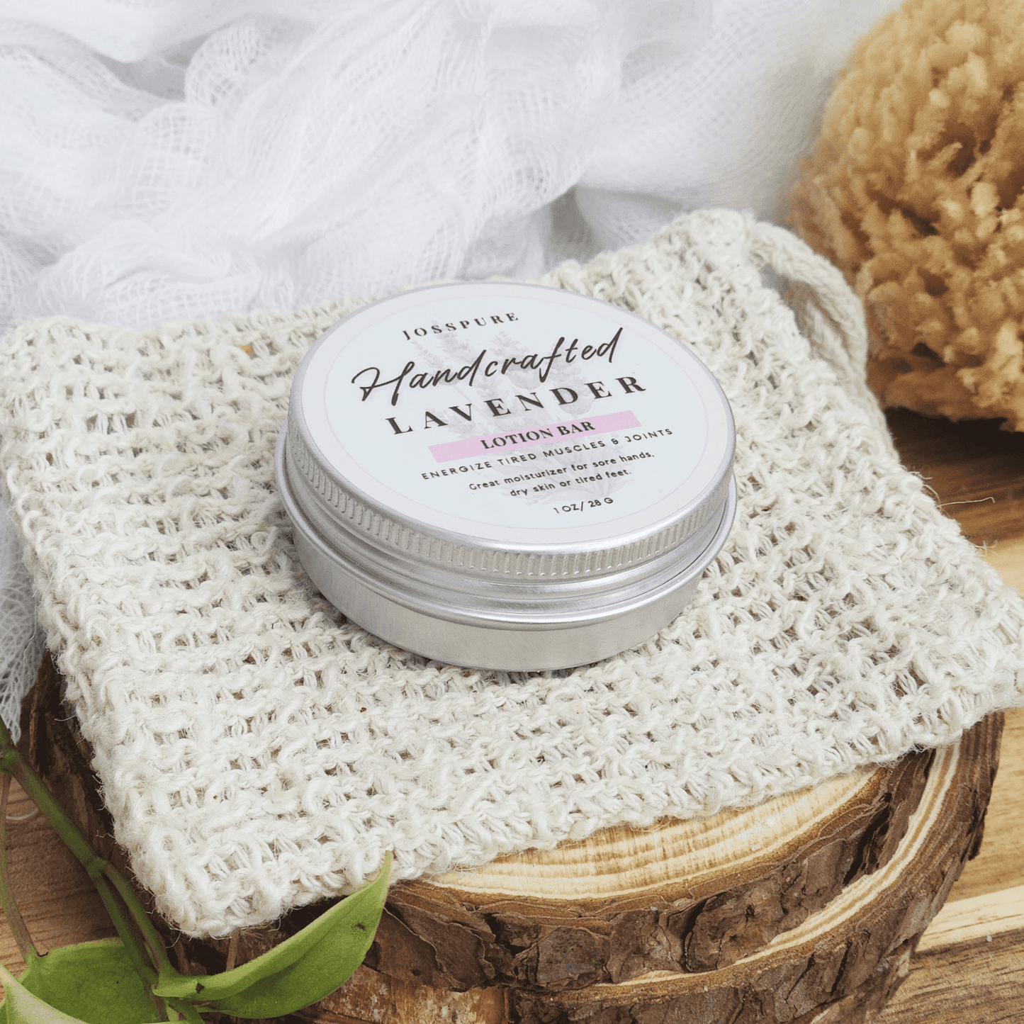 JOSSPURE lavender travel size mini lotion bar in metal tin on textured cloth with natural bath sponge