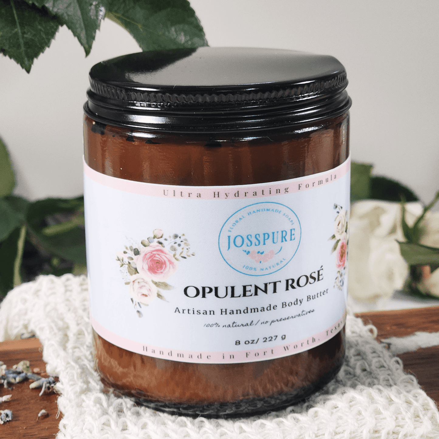 JOSSPURE rose mango butter whipped body butter in a brown jar with black lid on a knitted cloth