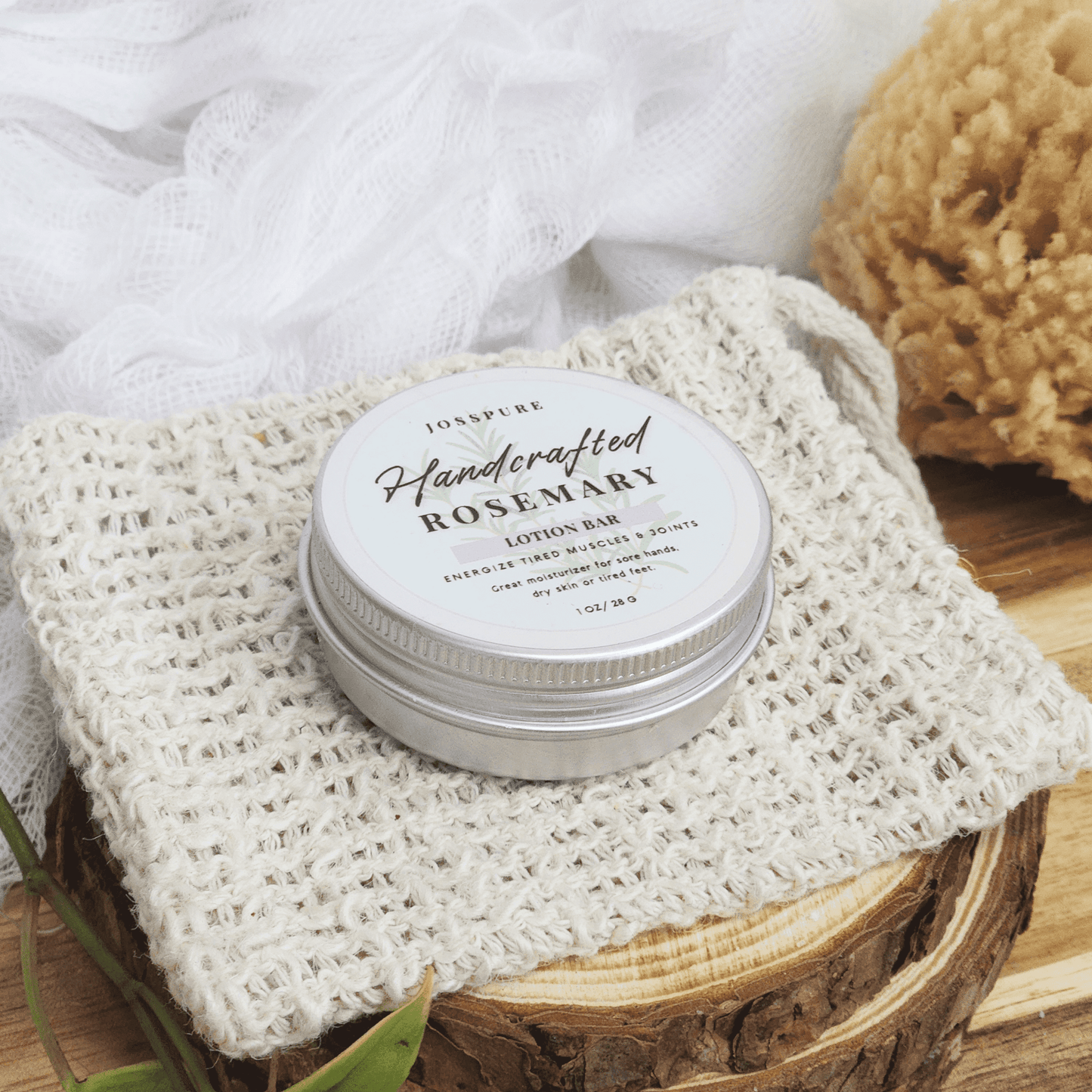 JOSSPURE rosemary travel size mini lotion bar in metal tin on woven cloth with wooden surface background