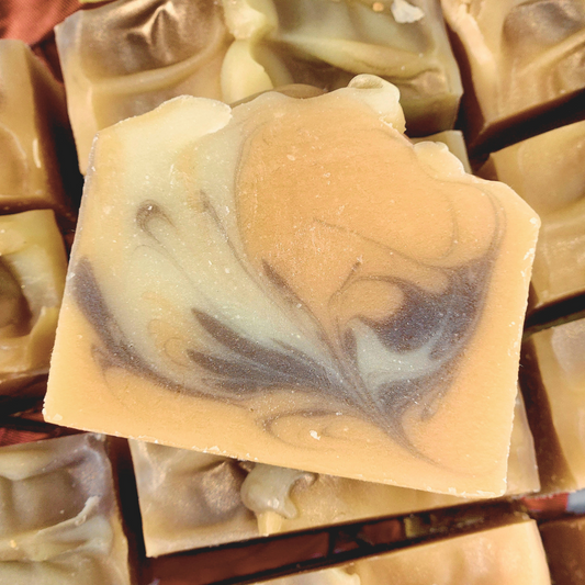 Luxurious orange clove fall soap featuring a creamy swirl design and warm autumn colors