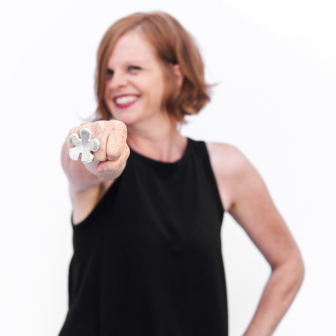 Woman smiling and holding a flower-shaped ring while promoting the 365 days of happiness book