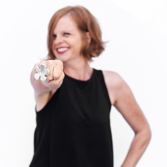 Woman smiling and holding a flower-shaped ring while promoting the 365 days of happiness book