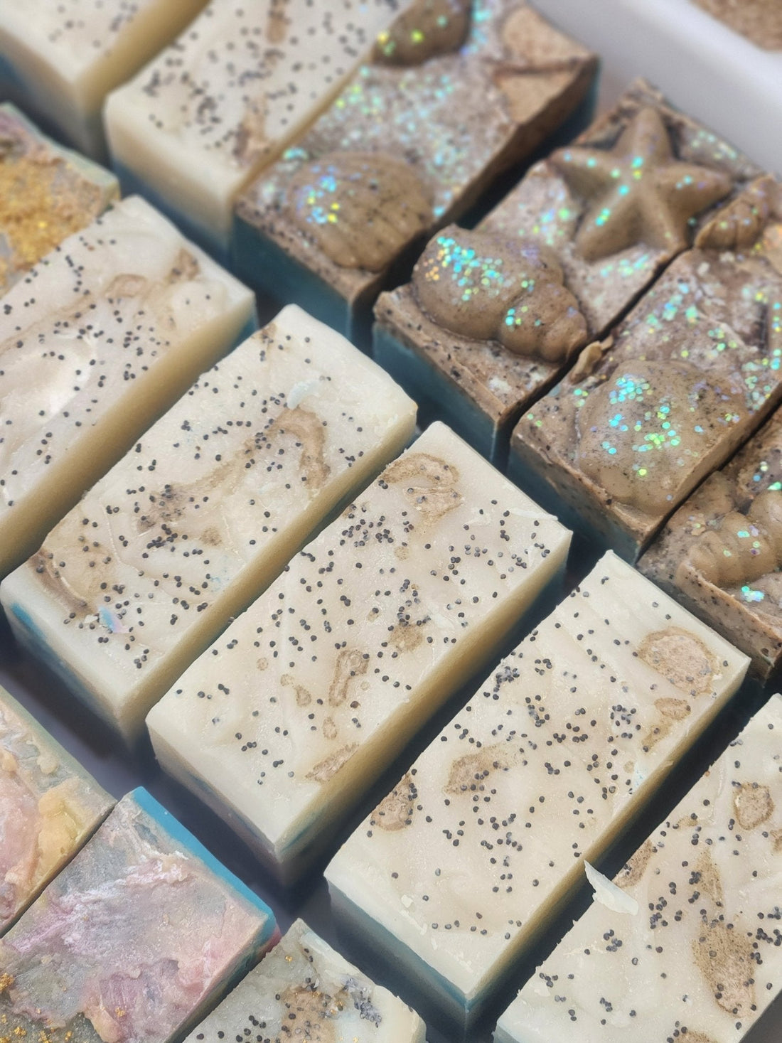 Handmade soap bars with natural ingredients arranged in rows for soap challenge ocean soap collection