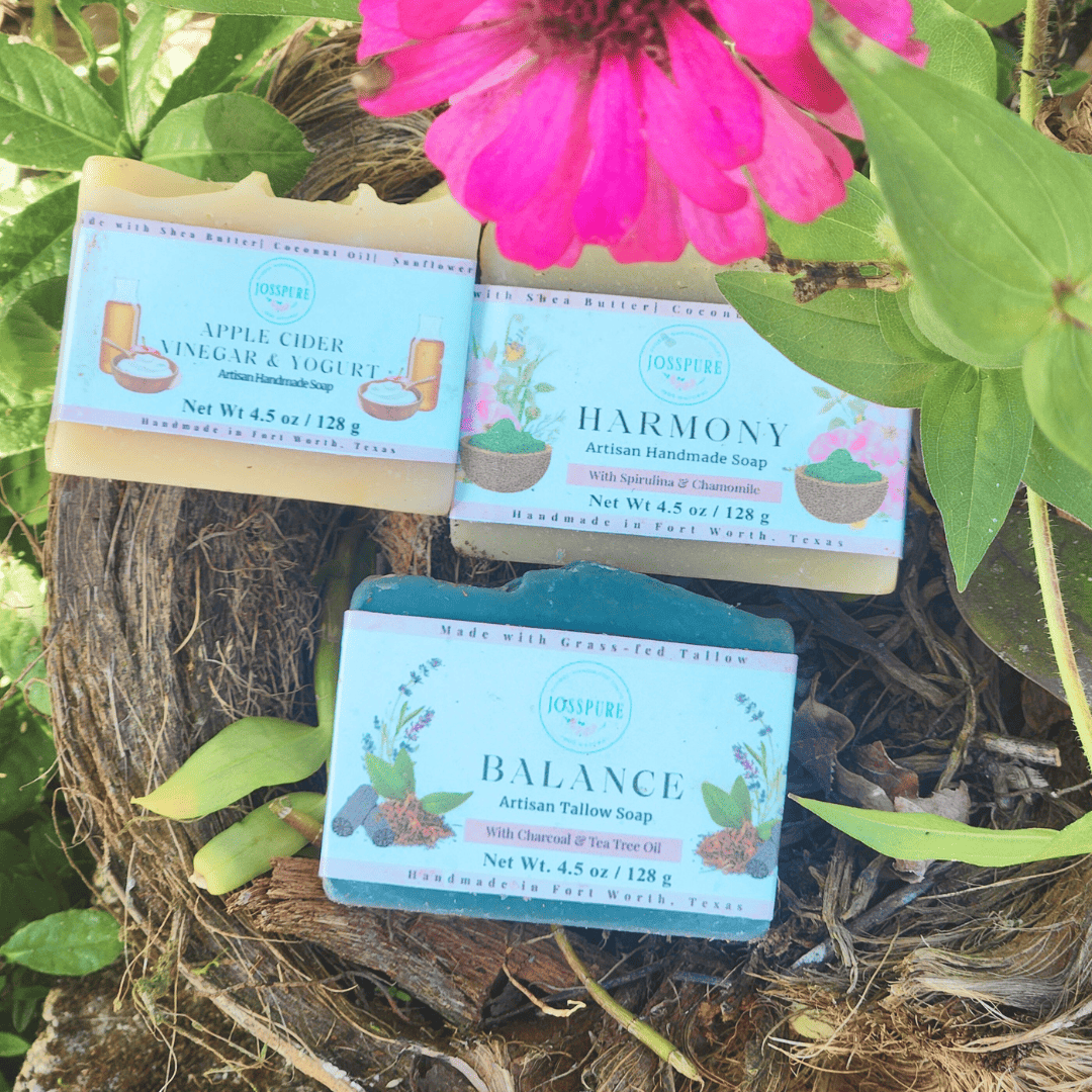 Three bars of soap with labels 'Harmony', 'Balance', and 'Apple Cider Vinegar & Yogurt' on a natural background with greenery.