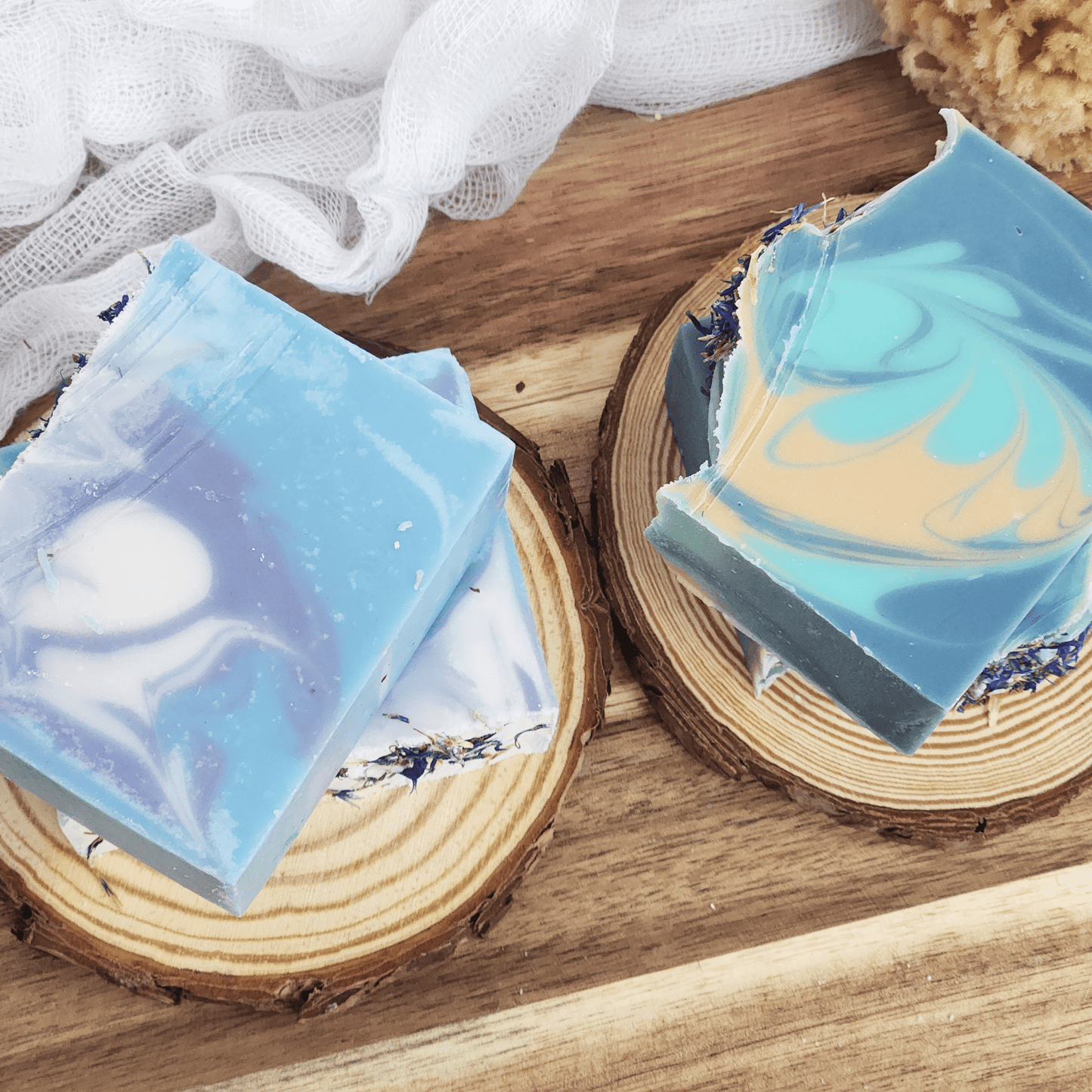 Blue and white handcrafted blackberry sage mild shea butter soap bars on wooden slices by JOSSPURE