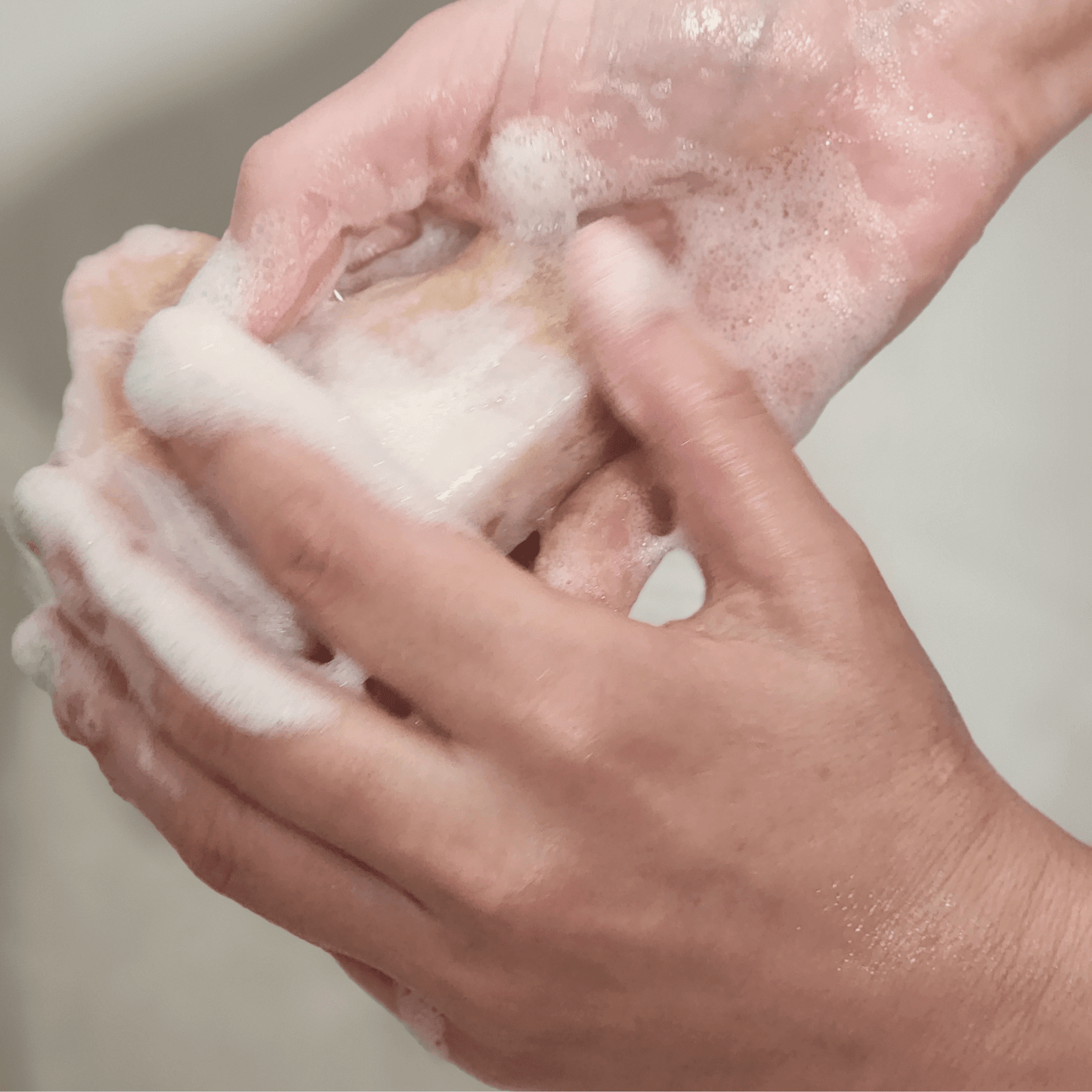 Hands lathering lemongrass mild shea butter soap creating rich foam for gentle cleansing