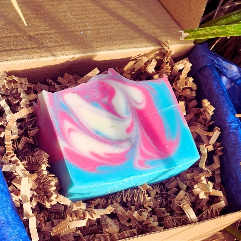 Colorful swirled soap bar in a box with brown crinkle paper