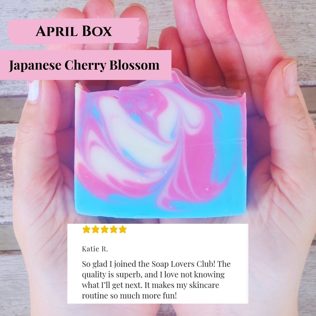Hand holding a Japanese Cherry Blossom soap with a five-star rating and customer review on a wooden surface.