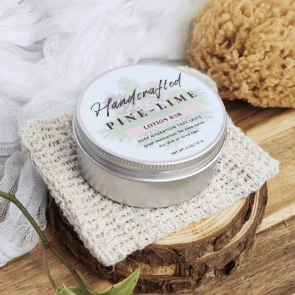 Handcrafted pine lime handmade lotion bars in a round silver tin on a textured cloth with natural decor