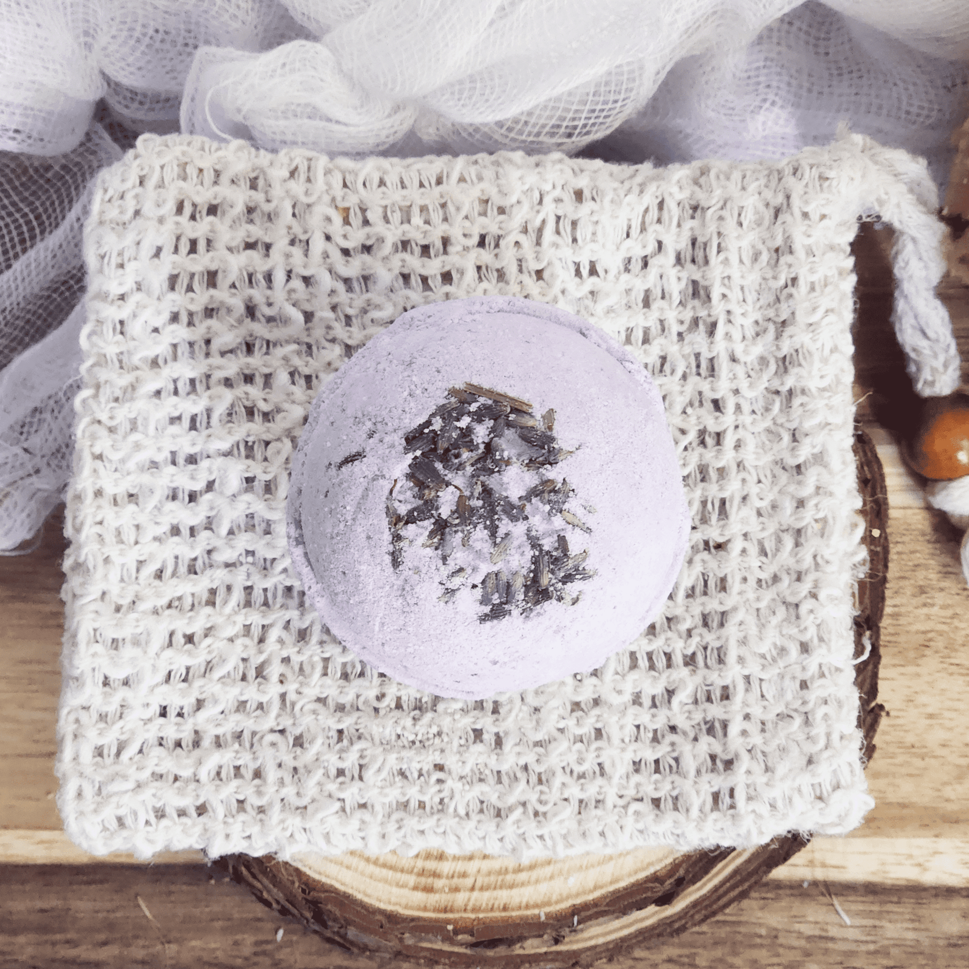 Lavender bath bomb with dried lavender petals on a woven white soap pouch by JOSSPURE