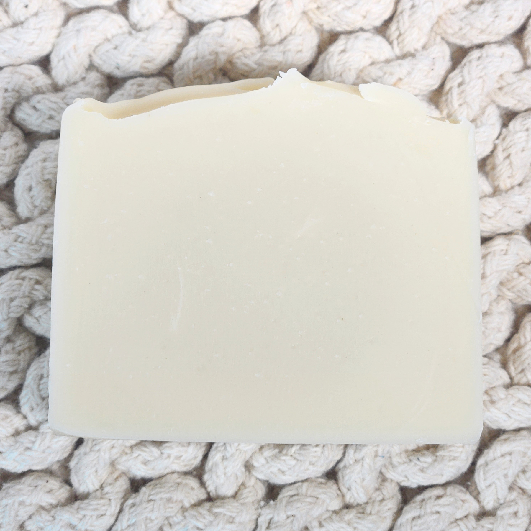 Natural lavender honey tallow soap bar on a textured background, ideal for gentle skincare