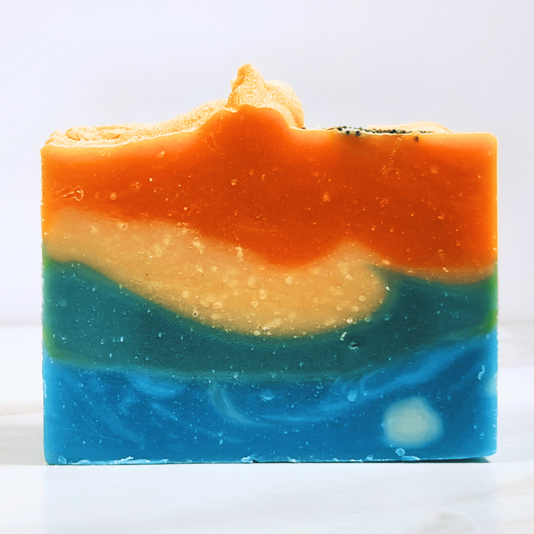 JOSSPURE handmade mango papaya shea butter soap with orange, cream, green, and blue layers