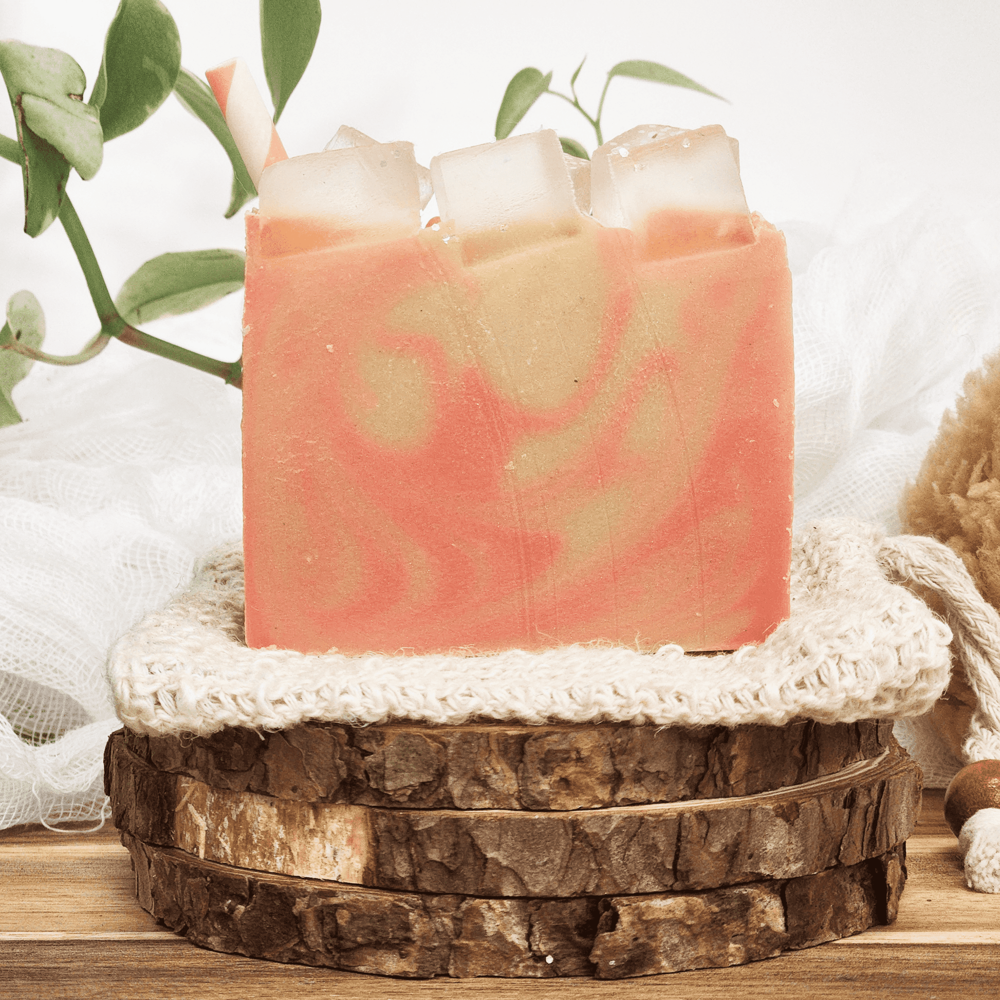 Handmade raspberry lemonade mild shea butter soap with pink and cream swirls displayed on wooden and fabric layers