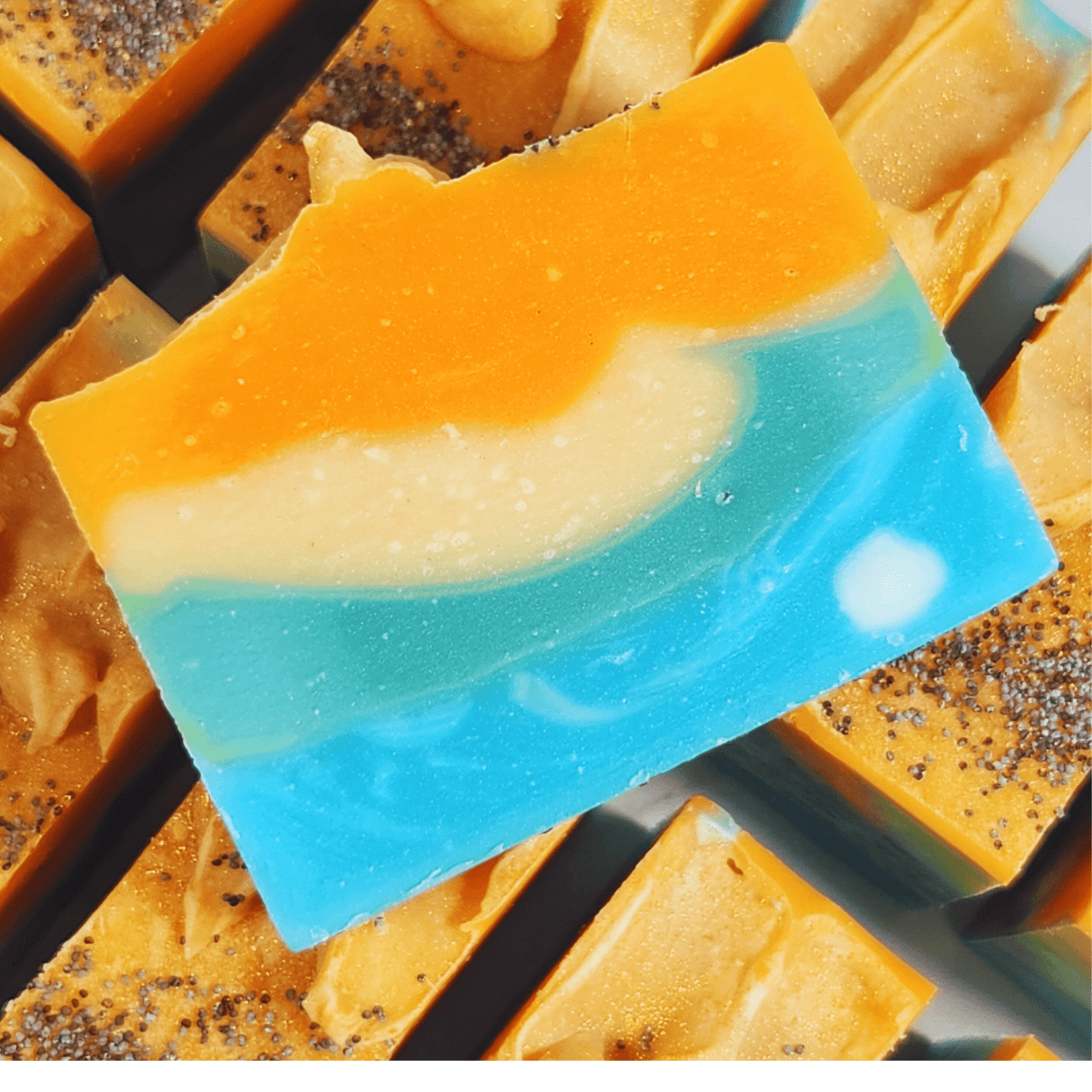 JOSSPURE handmade mango papaya shea butter soap with vibrant orange, cream, and blue layers