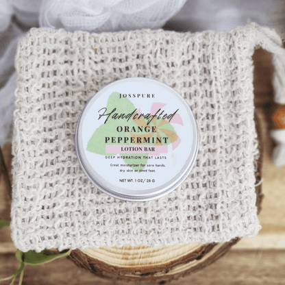 JOSSPURE peppermint orange Travel size mini lotion bar in a round tin on a woven natural cloth