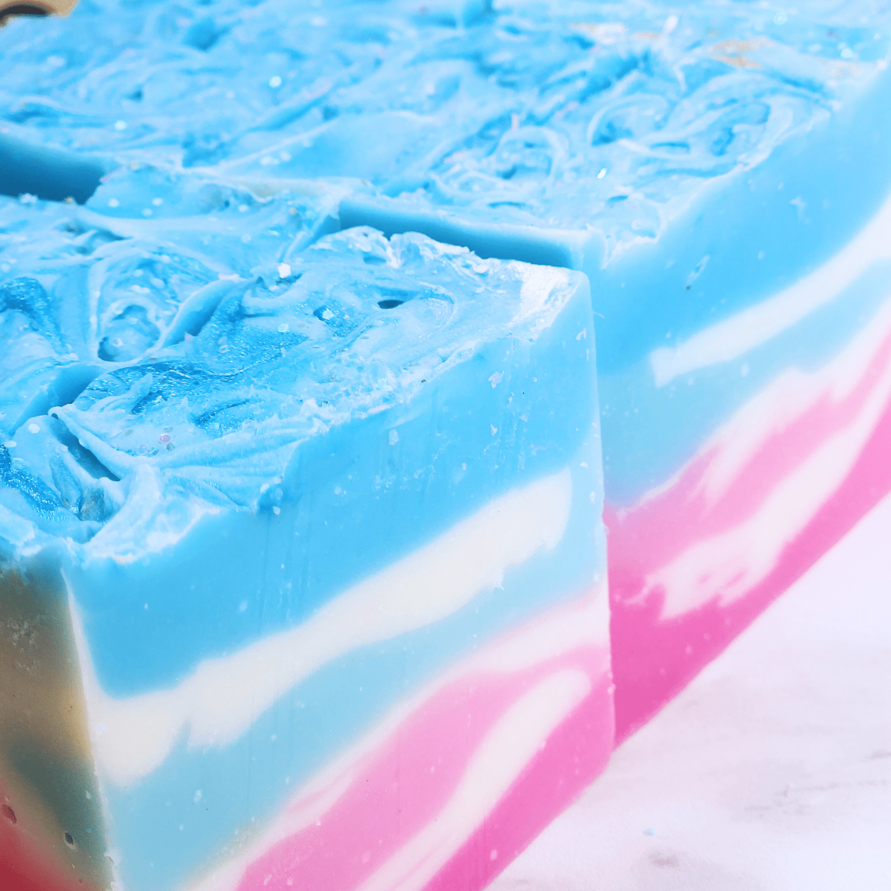 JOSSPURE handmade sea salt shea butter summer soap with blue, white, and pink layers