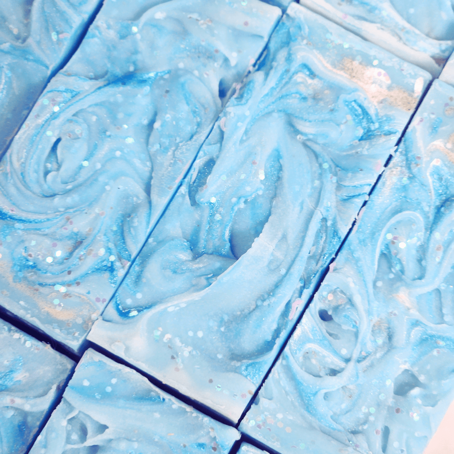 Blue handmade sea salt shea butter summer soap bars with swirled texture and glitter accents
