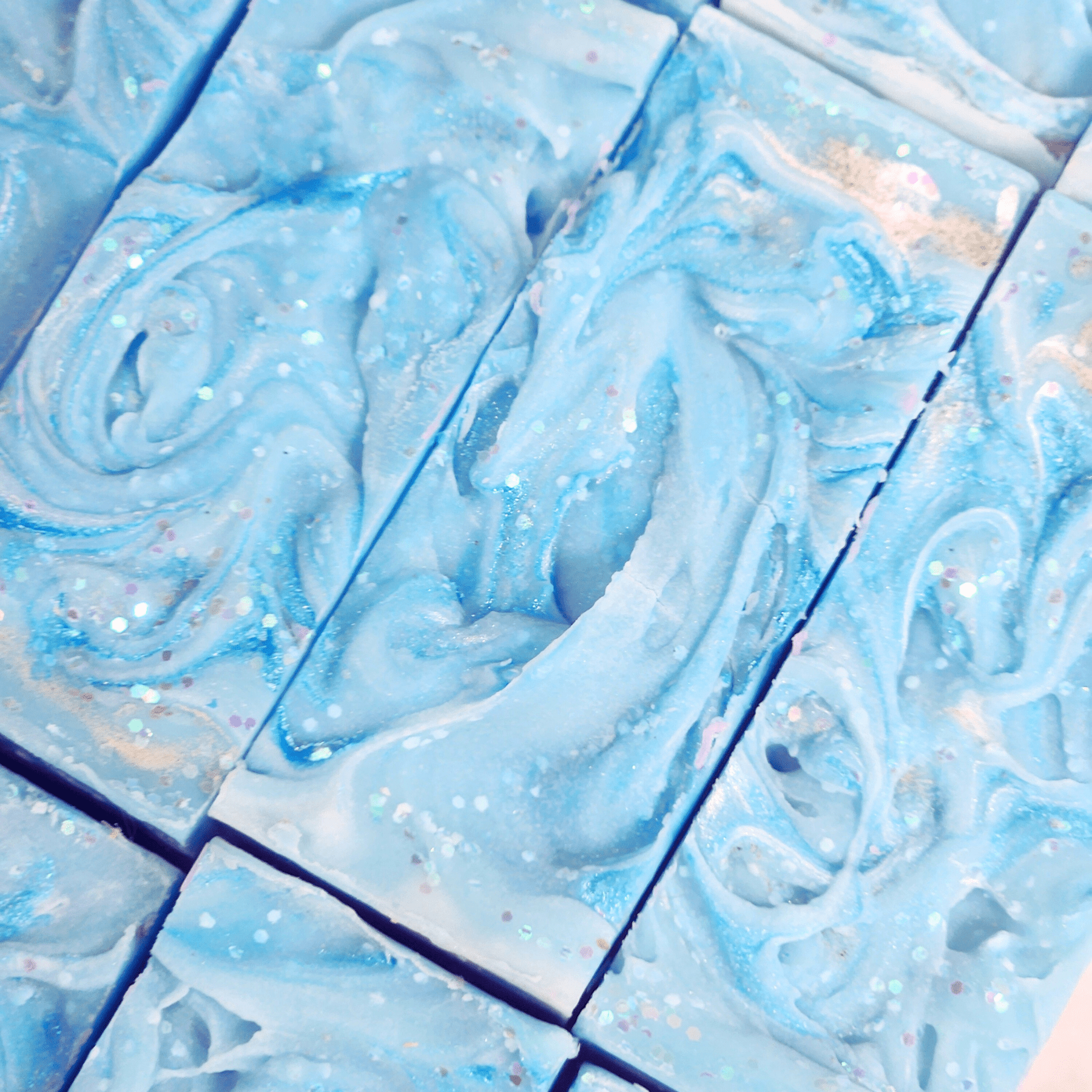 Blue handmade sea salt shea butter summer soap bars with swirled texture and glitter accents
