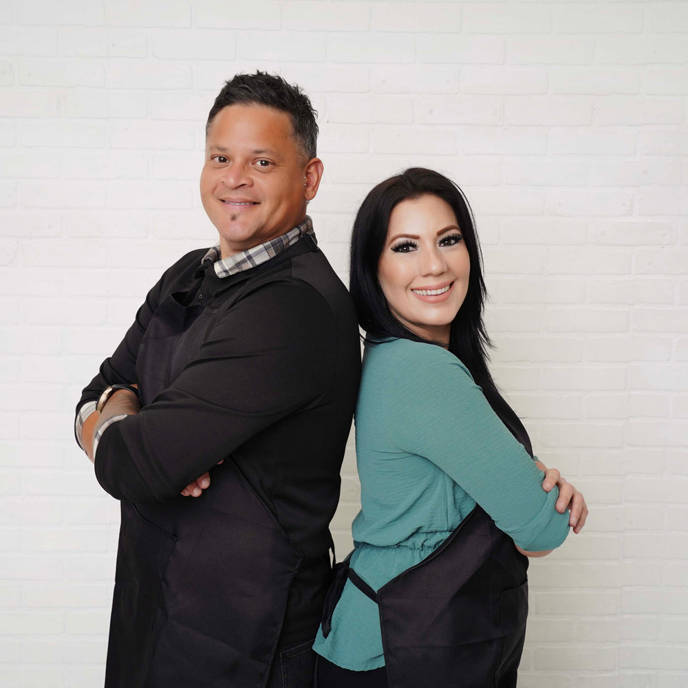 Two people standing back-to-back against a white wall
