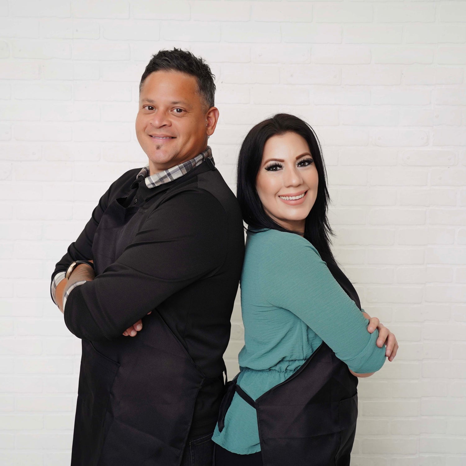 Two people standing back-to-back against a white wall