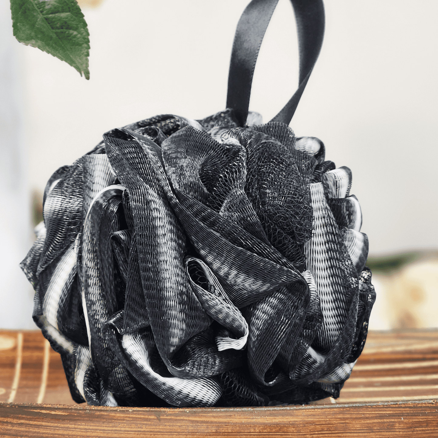 Black and white recycled eco friendly bath sponge hanging with textured soft mesh material