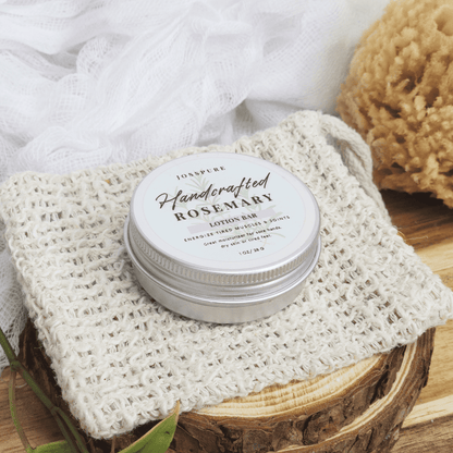 JOSSPURE rosemary travel size mini lotion bar in metal tin on woven cloth with wooden surface background