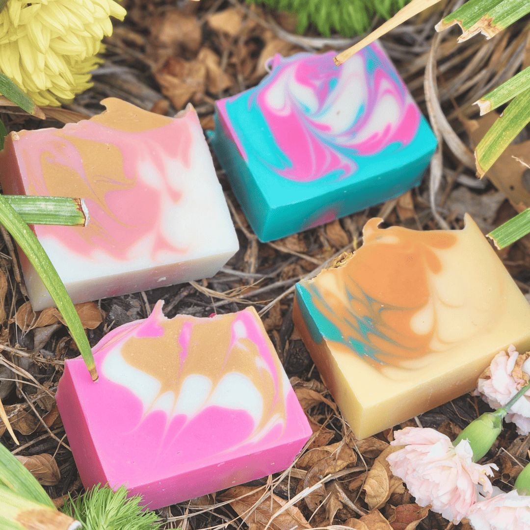 Colorful soap bars with a marbled design on a natural background with flowers.